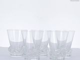 four glasses are lined up on a table with a white background