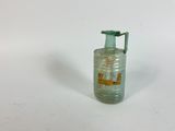 a small glass bottle with a handle on a white surface