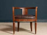 a brown leather chair sitting on top of a beige floor