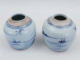 pair of blue and white vases sitting on a white surface