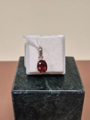 pendentif en argent sterling et en grenatite, posé sur un bloc de marbre