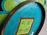 a blue vase with a green and yellow design on it