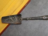 une cuillère en argent posée par terre à côté d'un chiffon jaune