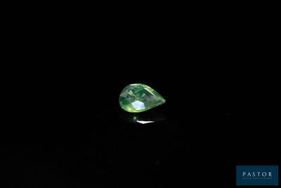 a close up of a green diamond on a black surface