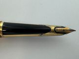 an image of a fountain pen with a gold tip and black nib