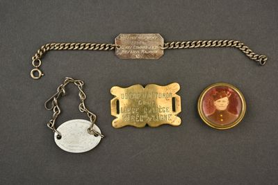 trois bijoux, dont un porte-clés, une pièce de monnaie et une médaille