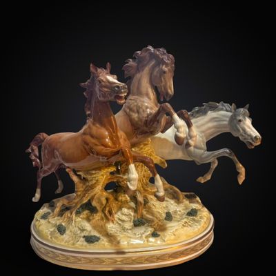 a statue of three horses that are running on a hill