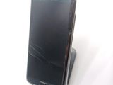 a cell phone with a broken screen sitting on top of a stand