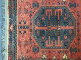 an old rug with fringes on a blue carpet next to a pair of scissors