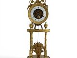 une horloge en or posée sur un socle, accompagnée d'un panier de fleurs