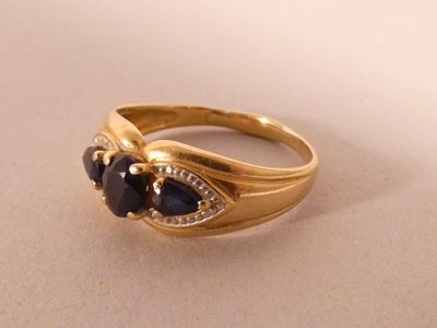 a close up of a gold ring with black stones on it