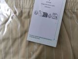 a label on the pants of a man that is laying on the bed