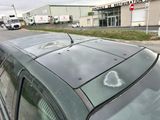 des voitures garées sur le bord de la route, avec des graffitis sur le toit