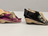 two pairs of shoes are sitting on top of a white table