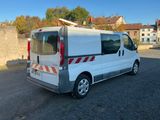 une camionnette blanche garée sur un parking, avec une planche de surf à l'arrière