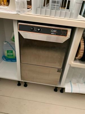 un lave-vaisselle au milieu d'une cuisine, avec de la vaisselle sur les étagères
