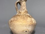 a brown vase that is sitting on a gray surface