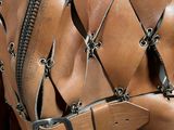 a close up of a brown leather jacket with zippers on it