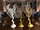 three vases that have branches on them on a table