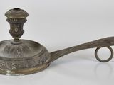 une théière ancienne en métal argenté, dotée d'une anse, sur fond blanc