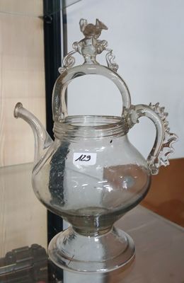 une théière en argent posée sur une table en verre
