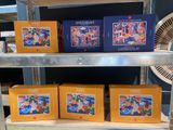 Plusieurs cartons contenant des articles variés sont posés sur une étagère dans un magasin.