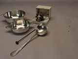 three silver bowls and spoons sitting on a table