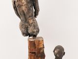 two sculptures of a boy and a dog on a white surface