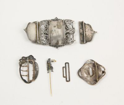 une photo d'une broche en argent, d'une épingle et d'autres objets