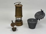 an image of a small metal object sitting next to a metal container