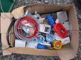 a cardboard box filled with electrical equipment on the ground