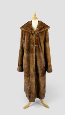 un manteau de fourrure marron posé sur un support de mannequin
