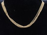 un collier de perles dorées sur un mannequin d'exposition