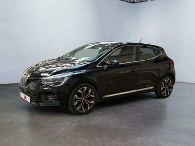 Une voiture noire est garée dans une pièce aux murs blancs.