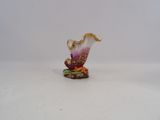 a small figurine of a flower on a white surface