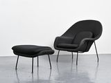 an image of a black chair and ottoman in a white room