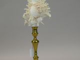 a gold vase with a white flower inside of it