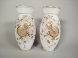 two white vases with gold designs on them