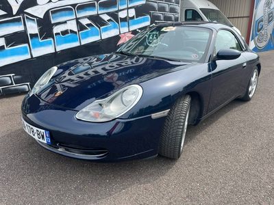 blue porsche 911 parked in front of a graffiti covered wall