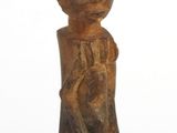statue en bois représentant un garçon coiffé d'un chapeau, posée sur un socle noir