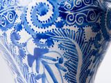a blue and white vase with a floral design on it
