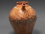 vase marron et blanc orné d'un motif en spirale sur un fond gris