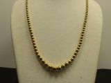 un collier en or sur un mannequin sur fond blanc