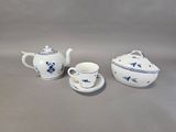 three pieces of blue and white porcelain tea set on a gray surface