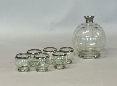 six glasses and a decanter sitting on a table