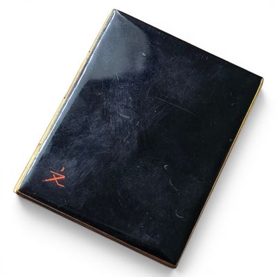un livre noir avec des inscriptions rouges sur une couverture blanche