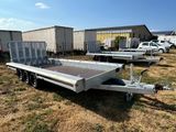 a silver trailer parked in a field with other trailers in the background