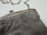an image of a silver purse with a chain around it