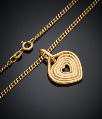 un collier en or avec un pendentif en forme de cœur sur une chaîne