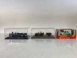 trois petites voitures sont exposées dans une vitrine posée sur une surface blanche